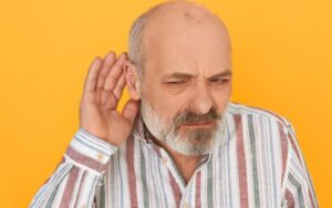 Qual a causa da perda auditiva relacionada a idade